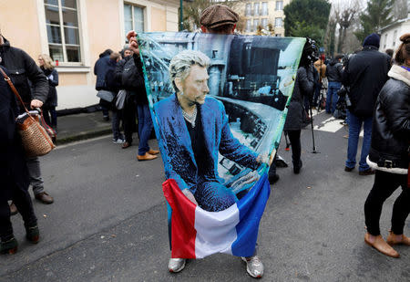 French fan Andre Duval poses with a poster of late French singer and actor Johnny Hallyday in Marnes-la-Coquette near Paris, France, December 6, 2017. REUTERS/Charles Platiau