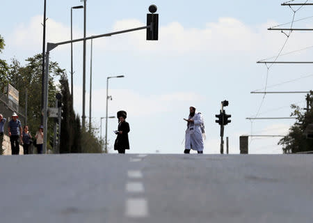 Jewish worshippers walk along an empty street in Jerusalem during the Jewish holiday of Yom Kippur, September 19, 2018. Most Israeli Jews refrain from driving during the 25-hour holy period. REUTERS/Ammar Awad