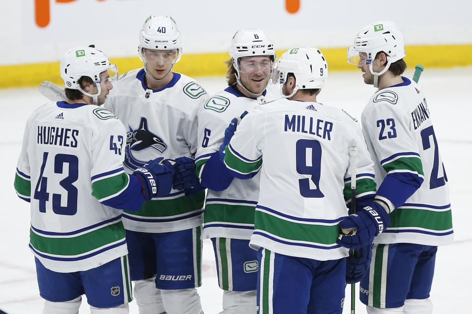 Vancouver Canucks' Quinn Hughes (43), Elias Pettersson (40), Brock Boeser (6), J.T. Miller (9) and Oliver Ekman-Larsson (23) celebrate Miller's goal against the Winnipeg Jets during the first period of an NHL hockey game, Thursday, Jan. 27, 2022 in Winnipeg, Manitoba. (John Woods/The Canadian Press via AP)