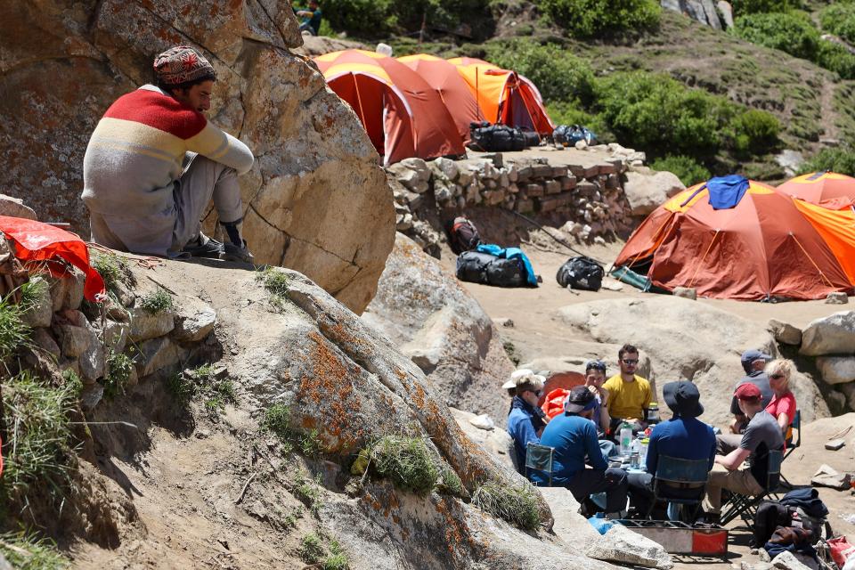 This picture taken on July 12, 2023, shows foreign tourists eating lunch whilst on the trail between Askole and K2.