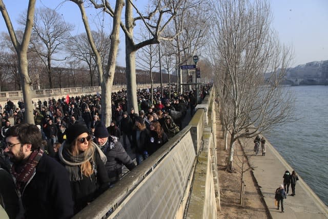 People march along the Seine river during a demonstration in Paris