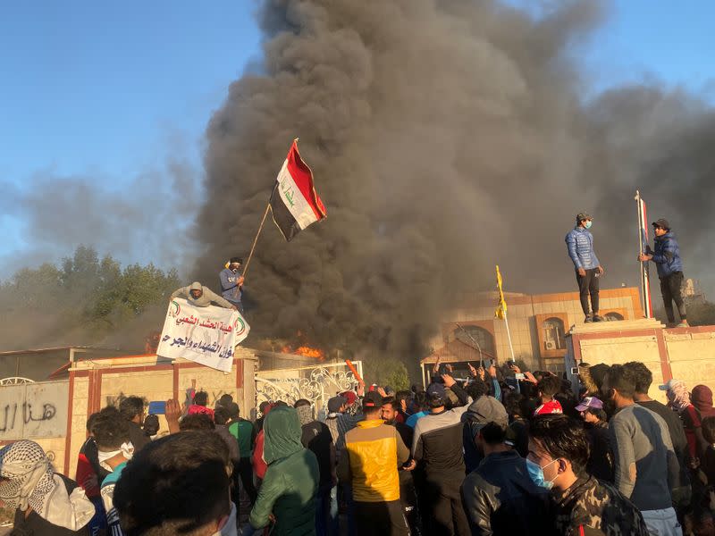 A headquarters building of Popular Mobilization Forces (Hashd al-Shaabi) burns after being torched by demonstrators during ongoing anti-government protests, in Nassiriya