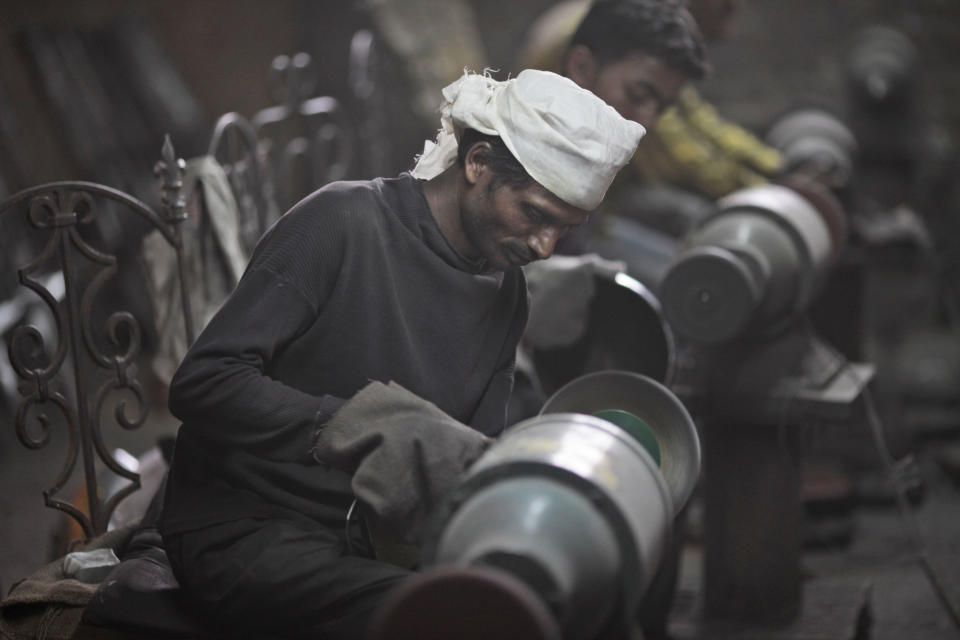 In this, June 2, 2012 photograph, workers prepare helmets for a Hollywood period movie at a workshop owned by Indian businessman Ashok Rai, unseen, in Sahibabad, India. From Hollywood war movies to Japanese Samurai films to battle re-enactments across Europe, Rai is one of the world's go-to men for historic weapons and battle attire.(AP Photo/Saurabh Das)