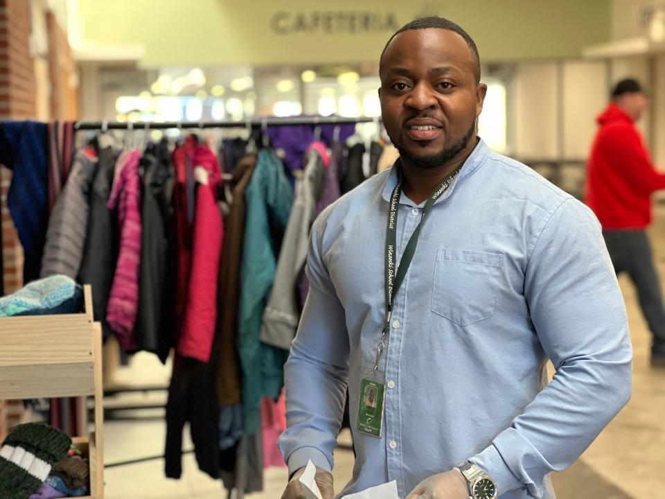 Patrice Lumumba is Winooski School District's Wellness Coordinator and also manages the Necessity Store, a shop where students and families can pick up grocery, hygiene and clothing items for free. Lumumba is standing in front of a rack of coats set up in the school lobby on February 21, 2023.