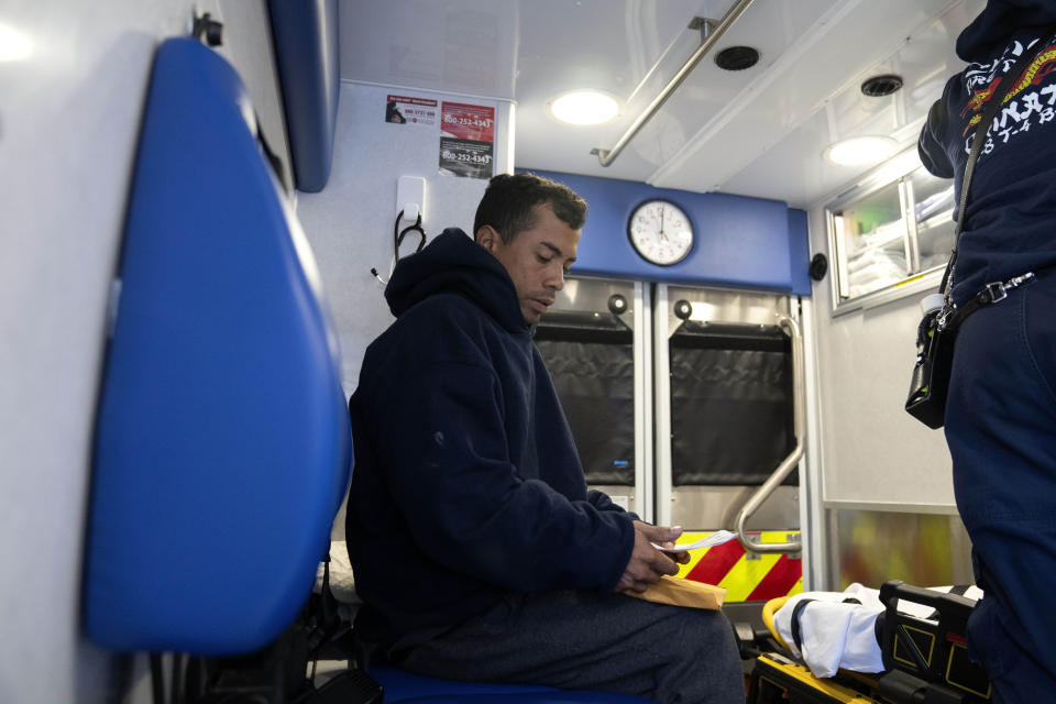 Moises Abraham Hidalgo Sarmiento, 30, of Peru is taken to the emergency room in an ambulance outside of the 1st District police station where migrants are camped Saturday, Oct. 7, 2023, in Chicago. (AP Photo/Erin Hooley)