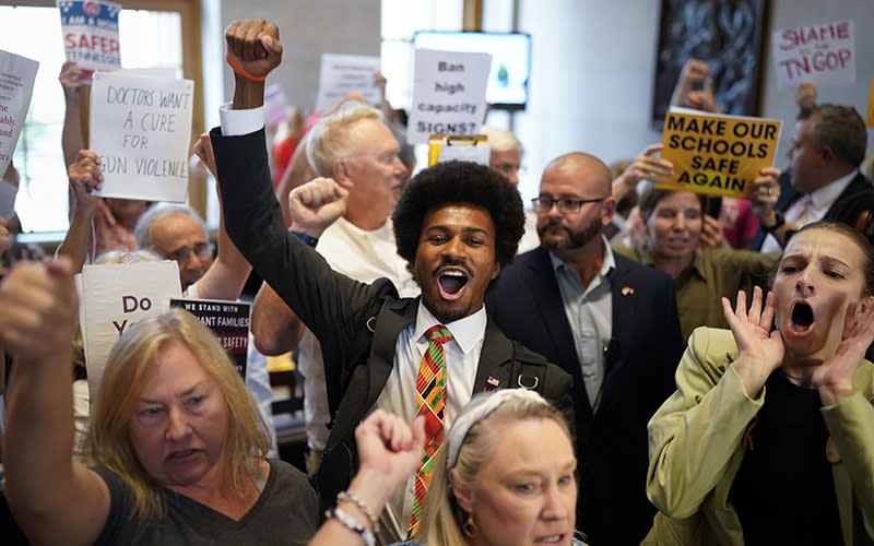 Rep. Justin J. Pearson, D-Memphis, center, raises his fist and protests with demonstrators outside the House chamber during a special session of the state legislature