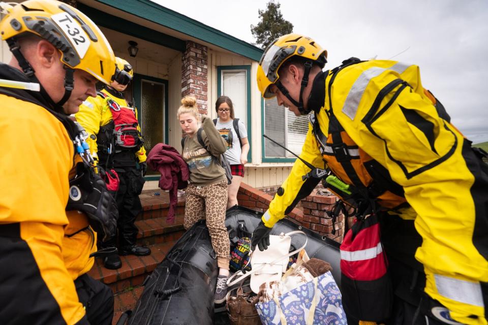 The Swift Water Rescue Team from Orange County pulls their Zodiac from a flooded area after rescuing a