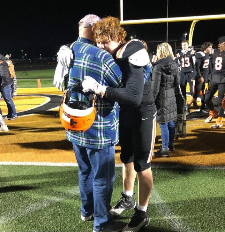 Jud Logan (left) hugs his nephew Drew following his final Hoover High School football game, a 2021 OHSAA playoff loss.