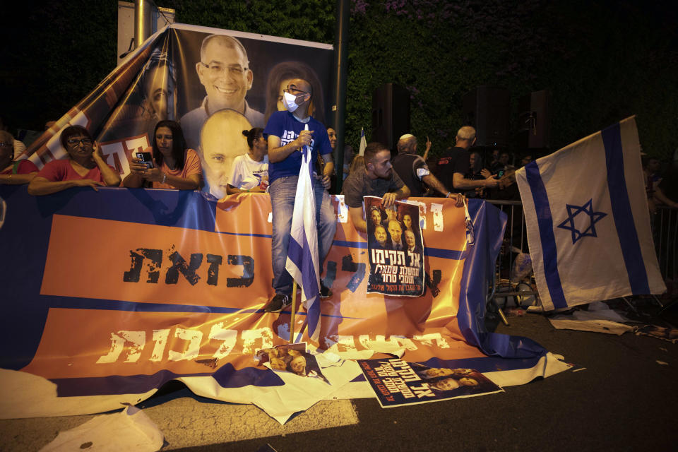 Israeli right-wing protesters chant slogans and hold flags during a demonstration against the forming of a new government in the central Israeli city of Ramat Gan, Wednesday, June 2, 2021. (AP Photo/Sebastian Scheiner)