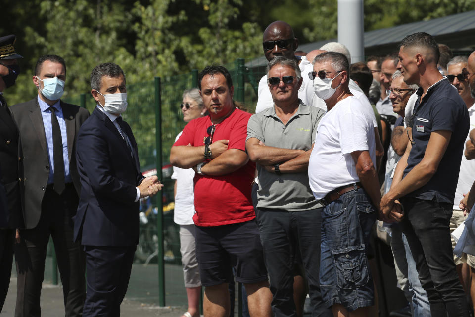 French Interior Minister Gerald Darmanin, left, arrives to talk with bus drivers in Bayonne, southwestern France, Saturday, July 11, 2020. The wife of a French bus driver savagely beaten after he asked four of his passengers to wear face masks aboard his vehicle called Saturday for "exemplary punishment" after he died of his injuries. (AP Photo/Bob Edme)