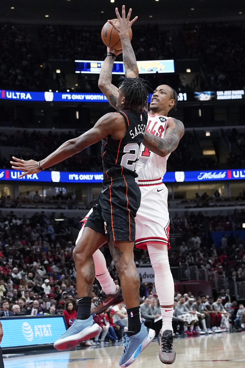 Chicago Bulls forward DeMar DeRozan, right, shoots against Detroit Pistons guard Marcus Sasser during the first half of an NBA basketball game in Chicago, Sunday, Nov. 12, 2023. (AP Photo/Nam Y. Huh)