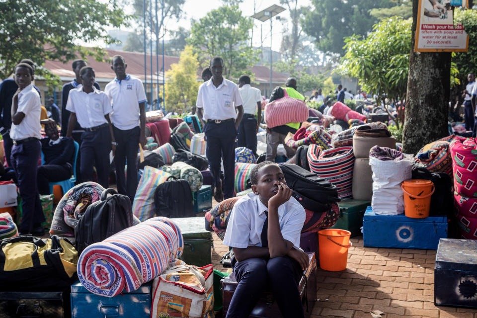 Students wait for their parents with their belongings to leave after a directive of the Health Ministry to close all schools two weeks earlier to curb the spread of Ebola at Naalya Senior Secondary boarding school in Kampala on November 25, 2022.