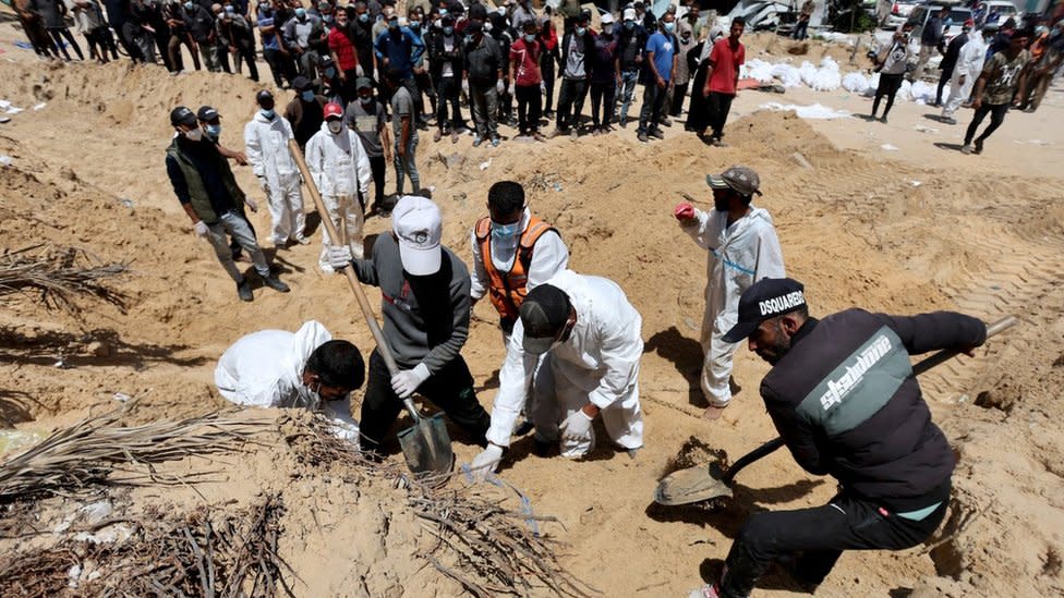 Palestinian civil defence workers dig mounds of earth in the grounds of Nasser hospital in Khan Younis, in the southern Gaza Strip (21 April 2024)