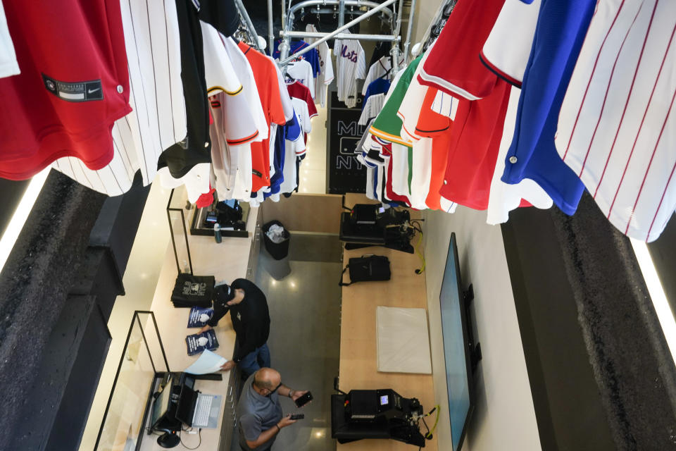 Workers prepare an area to customize jerseys at the MLB Flagship store Wednesday, Sept. 30, 2020, in New York. Major League Baseball’s first retail store opens Friday. (AP Photo/Frank Franklin II)