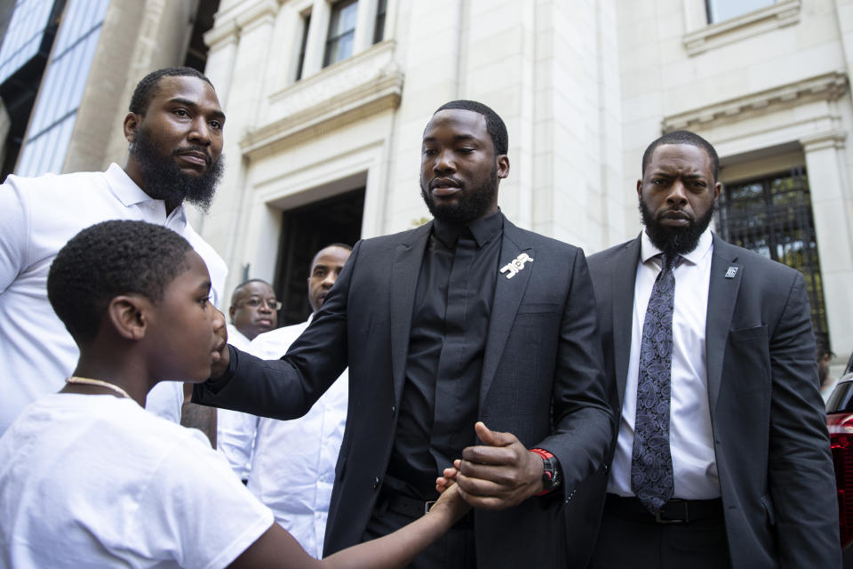 Rapper Meek Mill greets his son Rihmeek "Papi" Williams after a hearing at a Pennsylvania appeals court in Philadelphia, Tuesday, July 16, 2019. Lawyers for Mill asked an appeals court Tuesday to overturn a 2008 drug and gun conviction that has kept the rapper on probation for a decade and made him a celebrity crusader for criminal justice reform. (AP Photo/Matt Rourke
