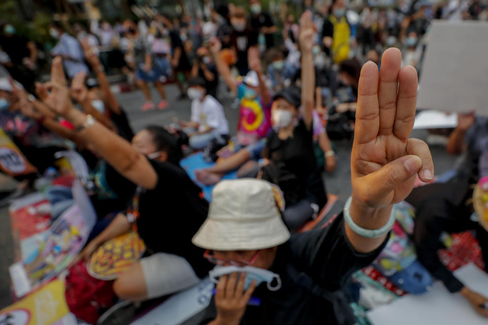 Pro-democracy activists flash a three-fingered symbol or resistance during a rally in Bangkok, Thailand, Wednesday, March 24, 2021, ahead of indictment against 13 protest leaders on Thursday for allegations of sedition and defaming the monarchy. (AP Photo/Sakchai Lalit)