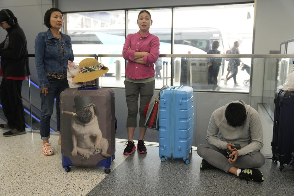 Travelers from Hong Kong wait for travel options after their vacation flight to Cancun, Mexico, was suddenly cancelled disrupting their planned vacation at the United Airlines terminal at Los Angeles International airport, Wednesday June 28, 2023, in Los Angeles. Travelers waited out widespread delays at U.S. airports on Tuesday, an ominous sign heading into the long July 4 holiday weekend, which is shaping up as the biggest test yet for airlines that are struggling to keep up with surging numbers of passengers. (AP Photo/Damian Dovarganes)