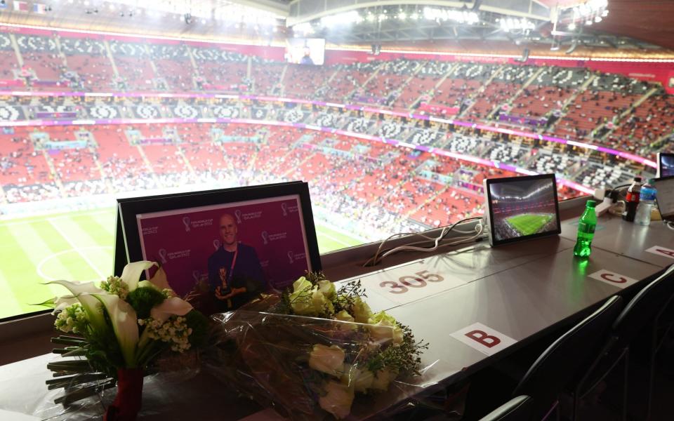 Flowers are laid at a media tribune desk in memory of the American journalist Grant Wahl - REUTERS