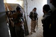 Fighters of the Syrian Kurdish People's Protection Units (YPG) hold a position during fighting against the Islamic State (IS) group in November 2014 in the Syrian besieged border town of Kobane