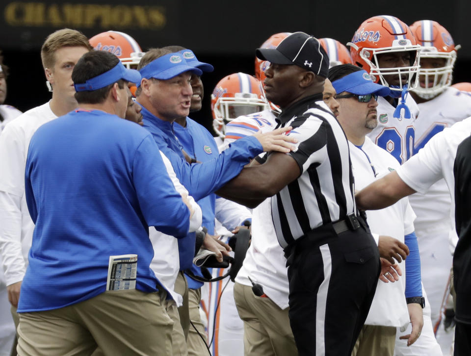 Florida head coach Dan Mullen, center, is restrained during a verbal confrontation with Vanderbilt coaches and players in the first half of an NCAA college football game Saturday, Oct. 13, 2018, in Nashville, Tenn. (AP Photo/Mark Humphrey)