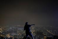 Anti-government protester reacts as he moves part of the "Statue of Lady Liberty Hong Kong" on the iconic Lion Rock in Hong Kong