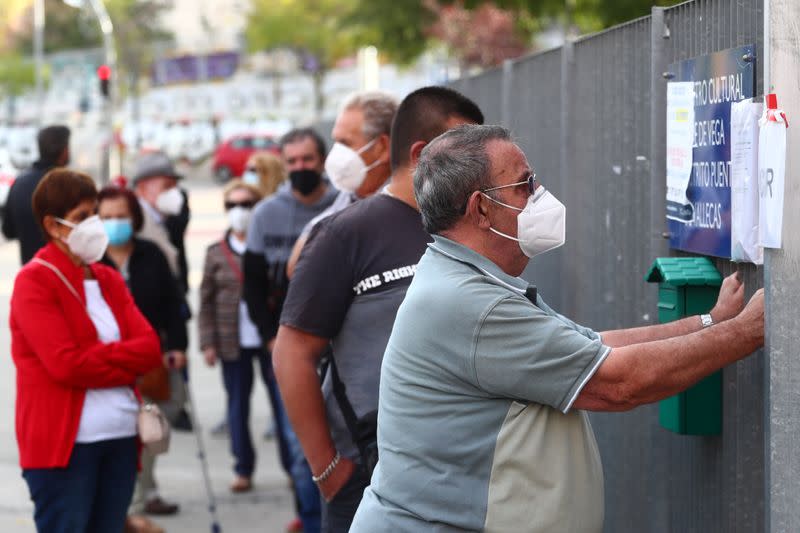 People wait in a queue outside a cultural centre before a coronavirus disease (COVID-19) antigen test in Madrid