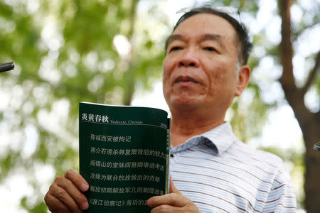 Wang Yanjun, former vice editor-in-chief of the liberal magazine Yanhuang Chunqiu, also known as China Through the Ages, holds an issue of the magazine as he speaks to the media outside the Chaoyang District Court in Beijing, China, August 16, 2016. REUTERS/Thomas Peter