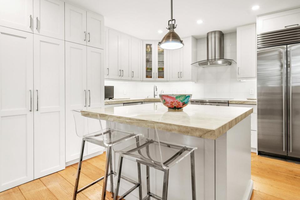 Features of the kitchen at Unit 2D in the 300 Building at 
300 S. Ocean Blvd. in Palm Beach include Shaker-style cabinetry, a center work island that accommodates pull-up seating, stainless-steel professional-grade appliances and quartzite counters and backsplashes.