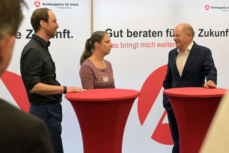 Germany's Chancellor Olaf Scholz (R) talks to Christian Klauss (L) and Franziska Reinhold, both employees of the employment agency during his visit to the Potsdam Employment Agency and the Jobcenter to find out about the so-called Job Turbo for the integration of refugees into the labor market and the "Spurwechsel" model project of the city of Potsdam. Michael Bahlo/dpa