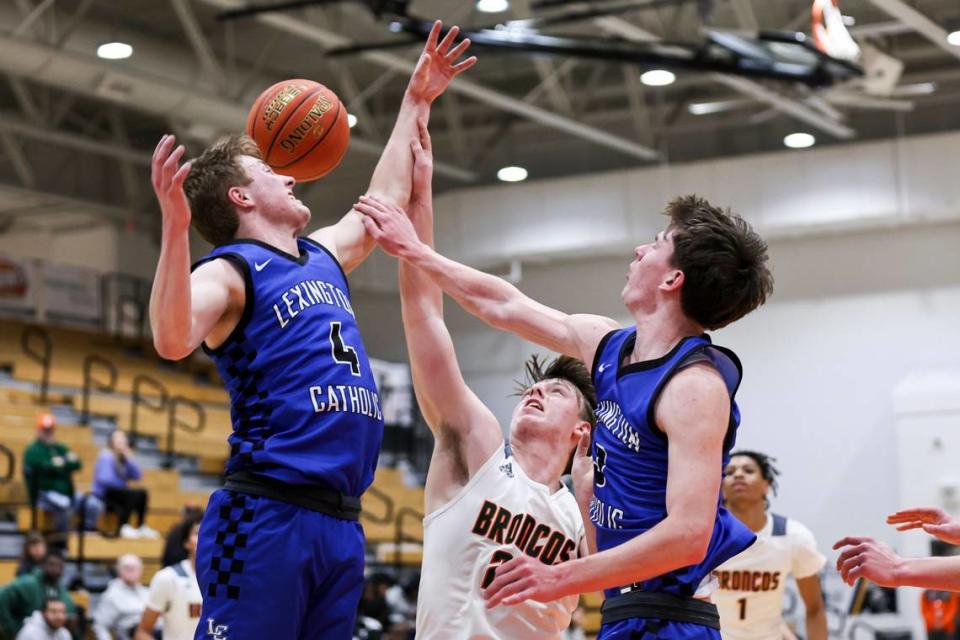 Lexington Catholic John Reinhart (4) blocks a shot by Frederick Douglass’ Logan Busson as teammate Tyler Doyle converged on the play during their game at Frederick Douglass High School in on Feb. 14.