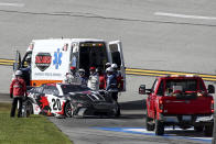 NASCAR Cup Series driver Christopher Bell (20) is helped after a collision during a NASCAR Cup Series auto race at Talladega Superspeedway, Sunday, April 21, 2024, in Talladega. Ala. (AP Photo/Greg McWilliams)