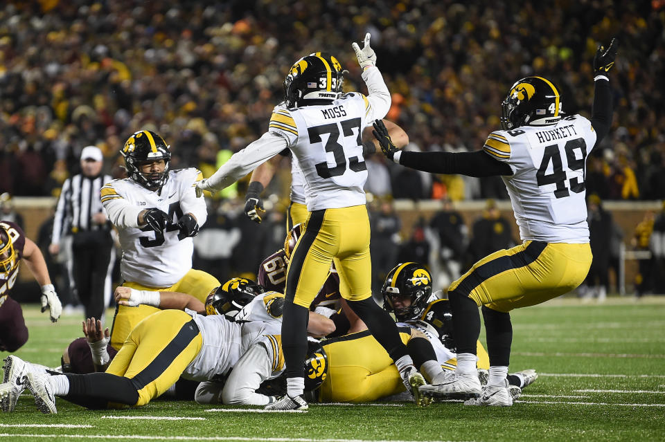 Iowa defensive lineman Yahya Black (94), defensive back Riley Moss (33) and defensive lineman Ethan Hurkett (49) celebrate after they recovered a fumble late in the second half an NCAA college football game against Minnesota on Saturday, Nov. 19, 2022, in Minneapolis. (AP Photo/Craig Lassig)