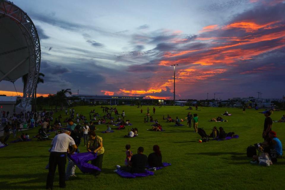 People are seen laying on the grass of the amphitheater as the sun sets during the inauguration of the eastern portion of Doral Central Park at 3005 NW 92nd Ave. in Doral, Florida, on Monday, Aug. 26, 2024.