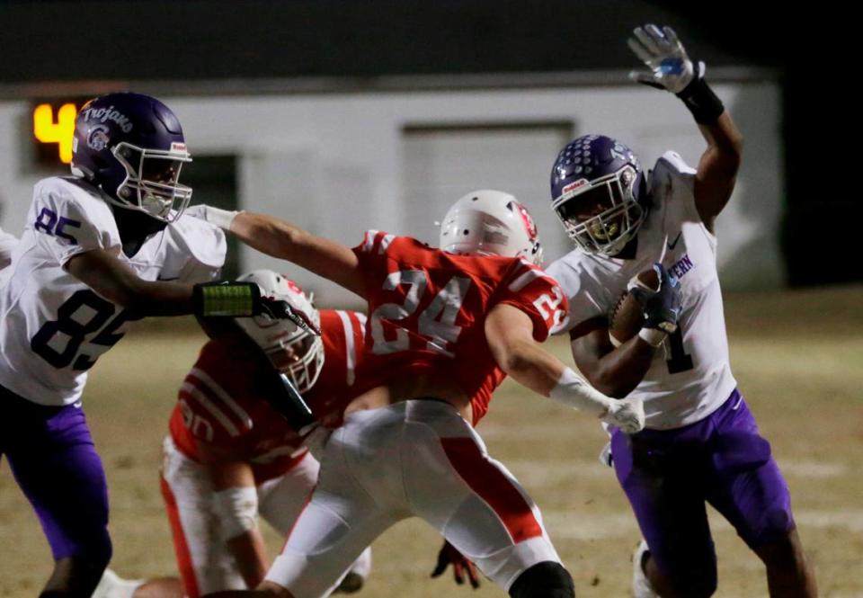 Northwestern’s Jalen Logan (85), left, holds off Greenville’s Riggs Faulkenberry as Turbo Richard, right, carries the ball Friday at the Class 4A Upperstate Championship game in Greenville, S.C.