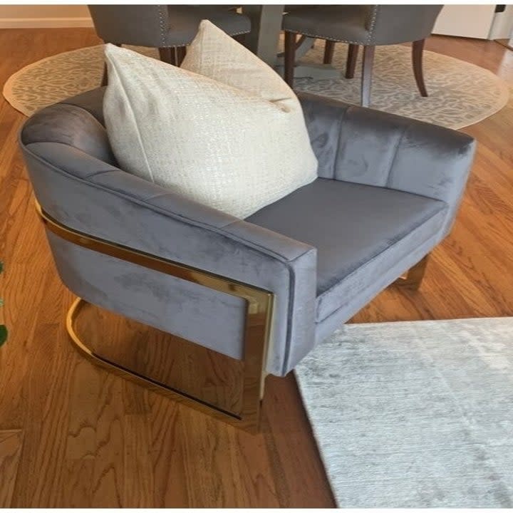 a reviewer photo of the gray chair with a white throw pillow