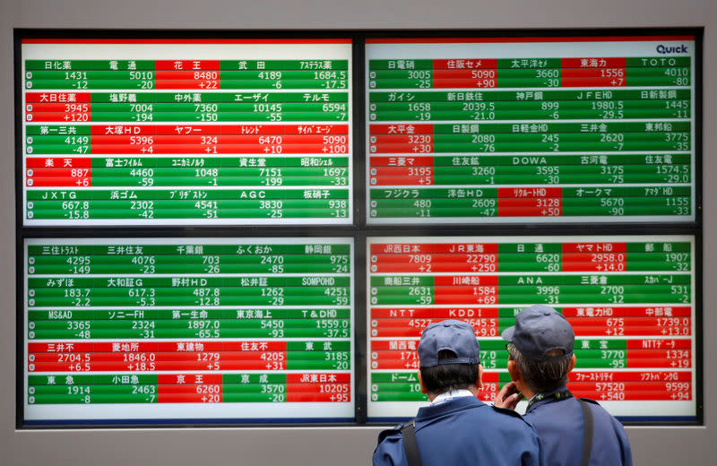 Men look at stock quotation boards outside a brokerage in Tokyo, Japan, December 5, 2018. REUTERS/Issei Kato/Files