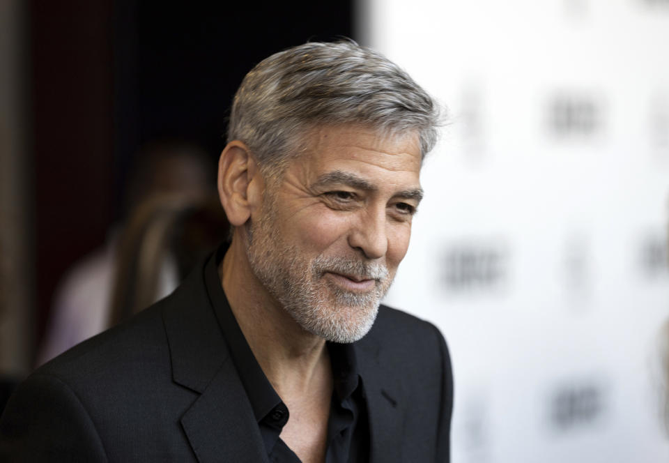 FILE - In this Wednesday, May 15, 2019, file photo, actor George Clooney talks to reporters on arrival at the premiere of the television mini-series "Catch22," in London. AARP is honoring Clooney with the career achievement award at its annual Movies for Grownups Awards. (Photo by Grant Pollard/Invision/AP, File)