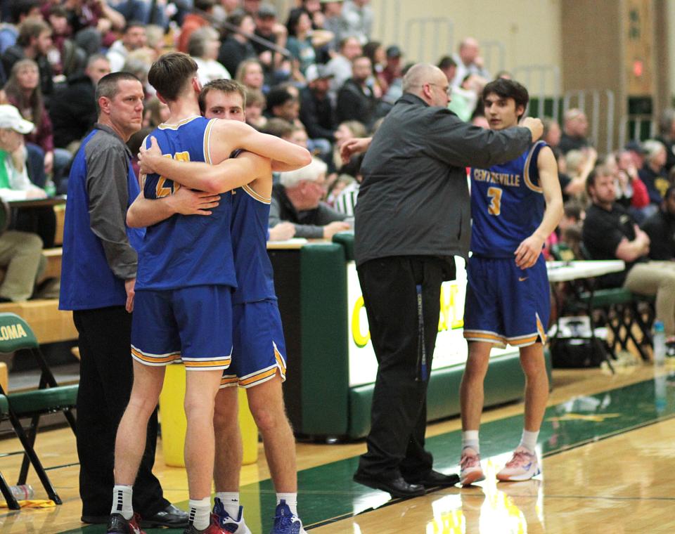 Centreville seniors Micah Lemings and Corey Carpenter share a hug while coach Matt Price gives a hug to Jacob Sikanas in the final moments of Wednesday's contest.