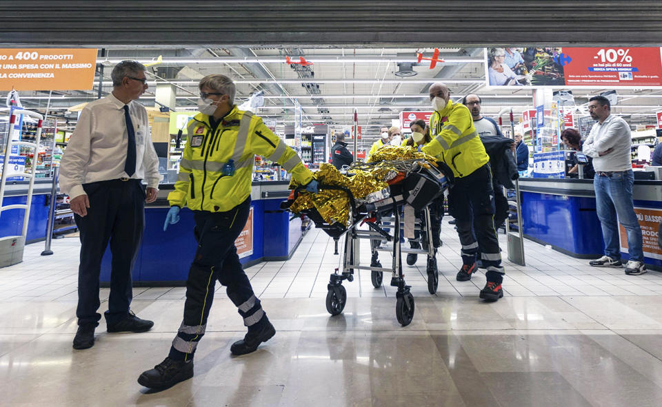 Emergency personnel, pictured here wheeling an injured person at the scene of an attack in Milan.