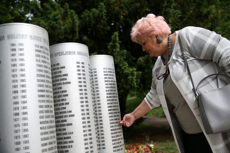 Zdravka Gvozdjar, mother of a murdered child, touches the monument for children killed during the siege of Sarajevo