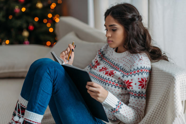 Woman journaling at Christmas. (Getty Images)