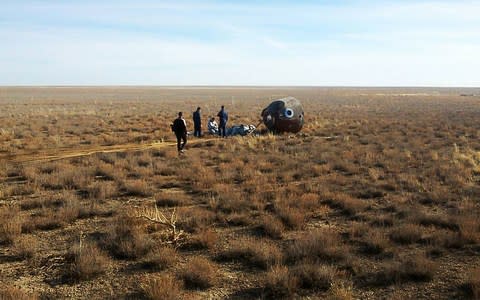 A rescue team arrives at the capsule after it crash landed in the grasslands of Kazakhstan 250 miles from Baikonur cosmodrome - Credit: Russian Central Military District/TASS via Getty Images