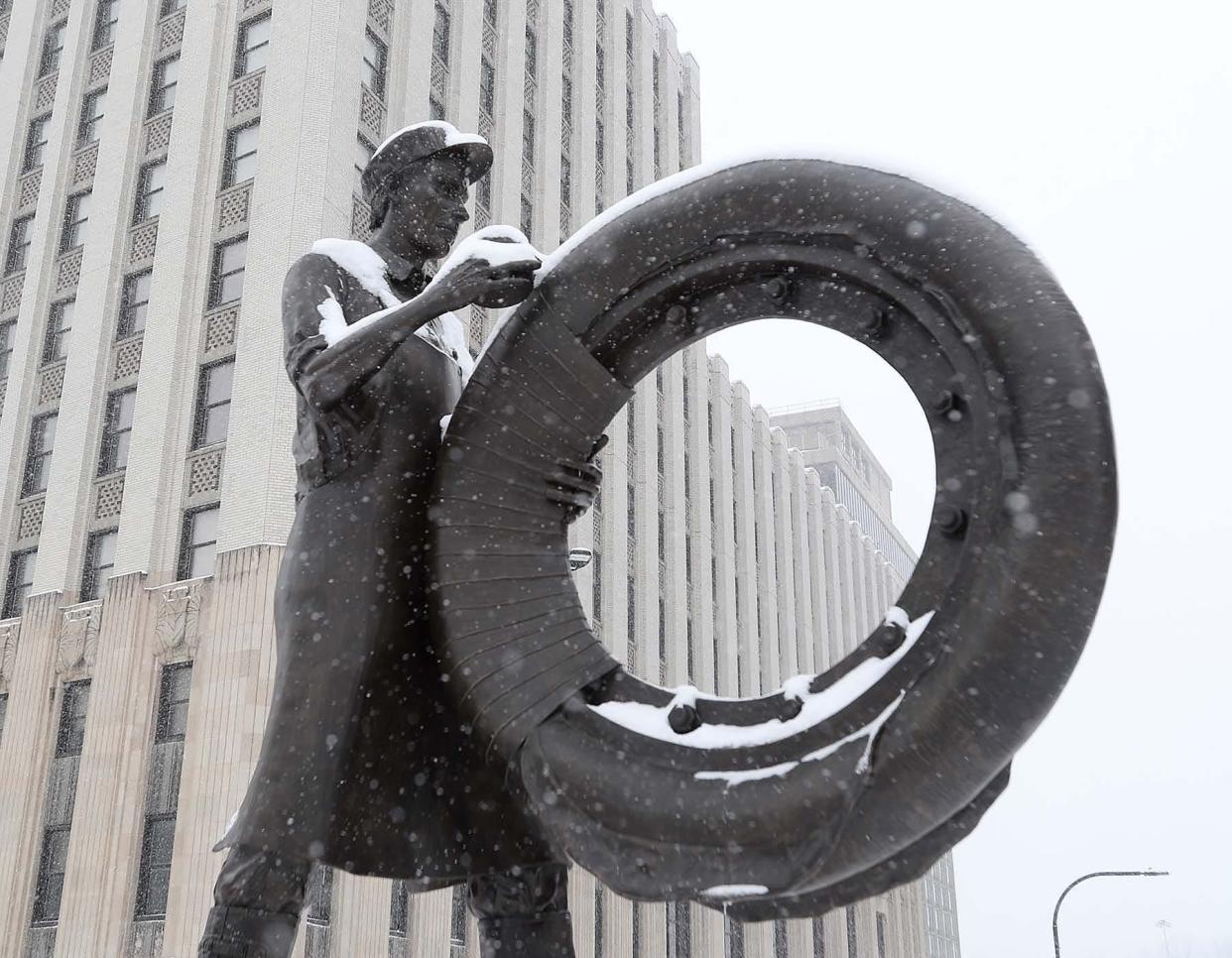 Snow covers the Rubber Worker sculpture as more snow falls in downtown Akron Monday.