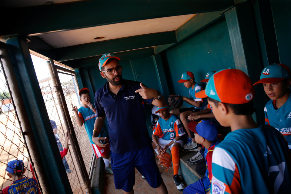 Daniel Boscan, coach of Cacique Mara little league baseball team, speaks with players prior to training at Cacique Mara stadium in Maracaibo, Venezuela. (Photo: Manaure Quintero/Reuters)