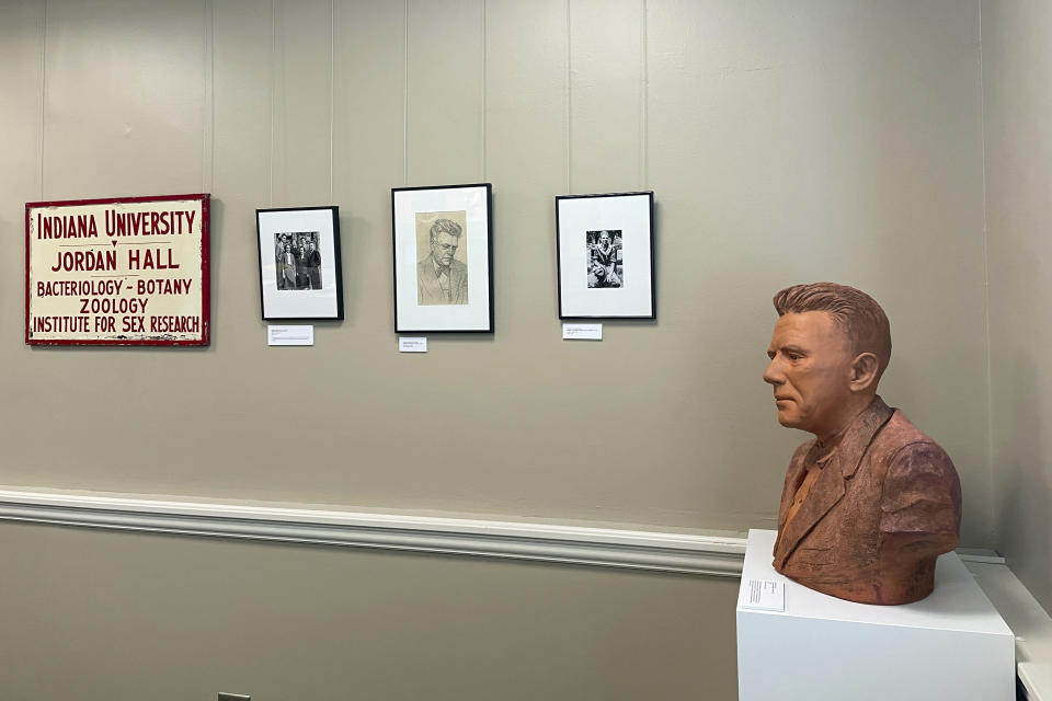 Sketches, photographs and an old university sign hang on the wall inside a reading room of the Kinsey Institute, while a bust of Alfred Kinsey, its founder, is on display in the corner, Tuesday, May 16, 2023, in Bloomington, Ind. (AP Photo/Arleigh Rodgers)