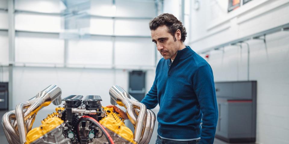 dario franchitti stands over the engine of a gordon murray t33