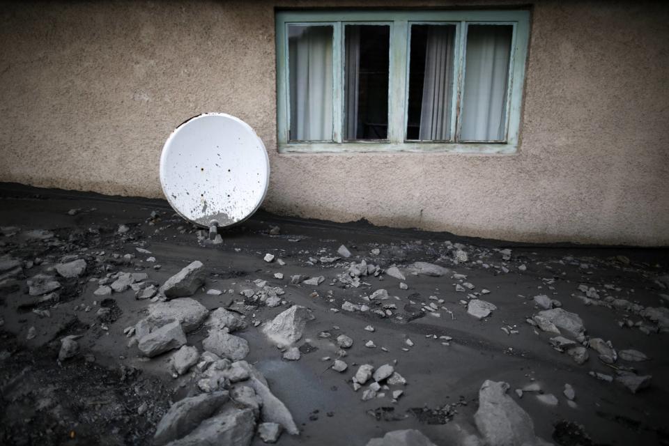 A satellite dish sits amidst debris near the window of a flood-damaged house in Topcic Polje