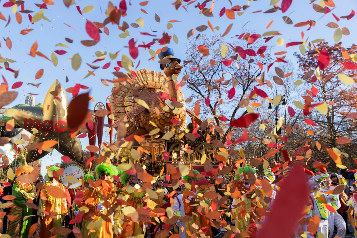 Confetti in front of a turkey parade float with blue skies in the background.