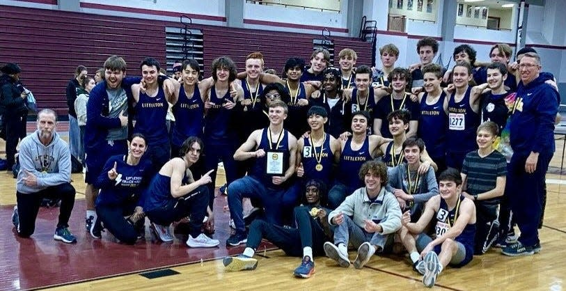 Athletes and coaches from the Littleton boys' indoor track team celebrate the win at the Mid-Wach C Championships Friday at Fitchburg High.