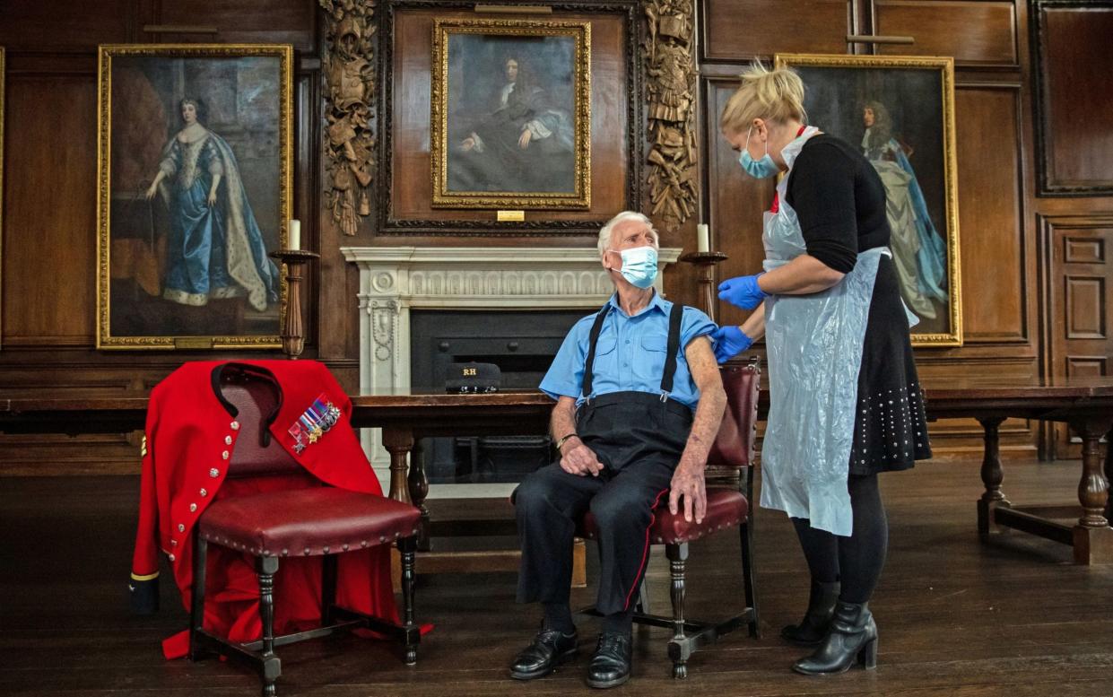 D-Day veteran and Chelsea Pensioner Bob Sullivan, 98, is injected with the Pfizer vaccine by Pippa Nightingale, Chief Nurse at the nearby Chelsea and Westminster Hospital - Aaron Chown/PA Wire